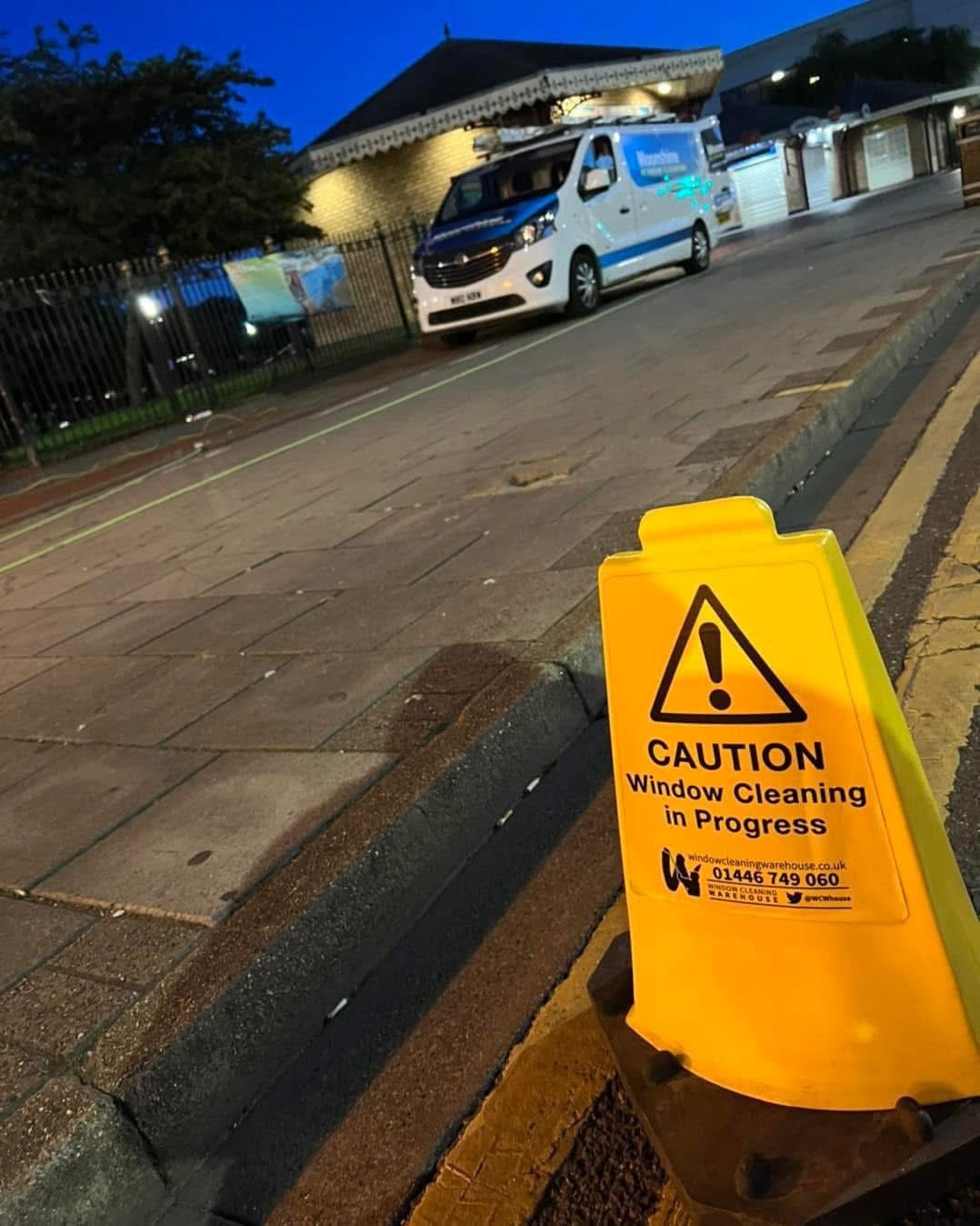 Moonshine Window Cleaning sign-written van and wet floor safety signs in use during early morning commercial window clean in Boston Lincolnshire