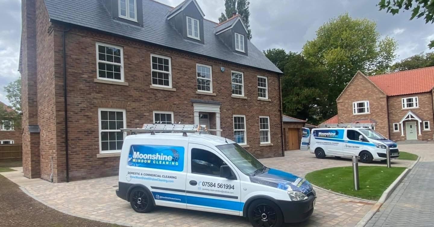 Both Moonshine Window Cleaning vans outside luxury new-build development for builder's clean before handover to new home owners in Lincolnshire