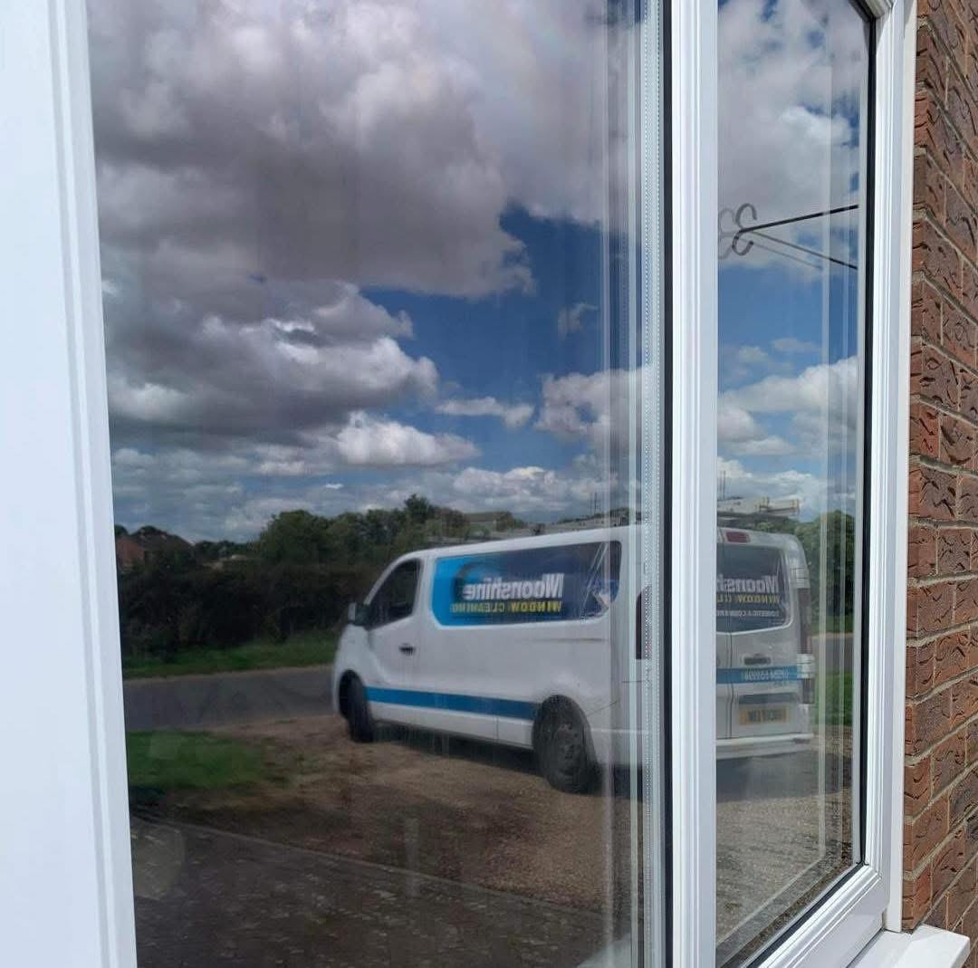 Spotless window reflecting the Moonshine Window Cleaning van — streak-free results in Lincolnshire